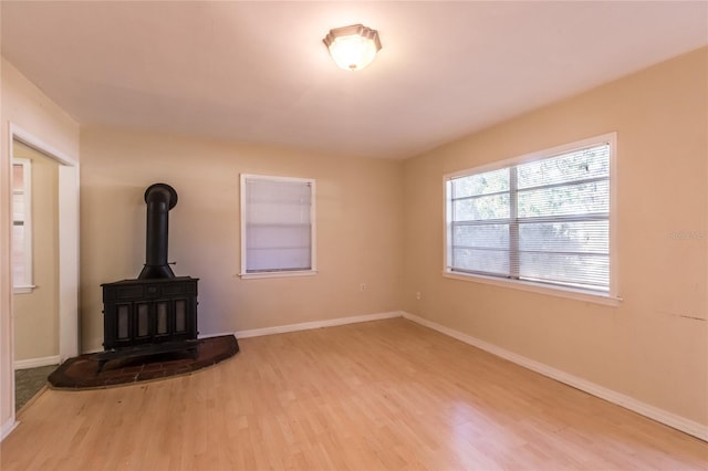 unfurnished living room featuring light hardwood / wood-style floors and a wood stove