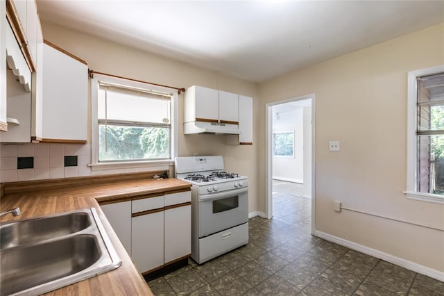 kitchen featuring butcher block counters, gas range gas stove, sink, backsplash, and white cabinets