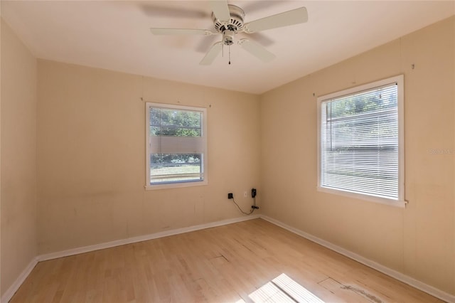 empty room with ceiling fan, a healthy amount of sunlight, and light wood-type flooring