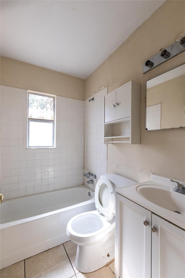 full bathroom featuring tile patterned flooring, vanity, toilet, and tiled shower / bath