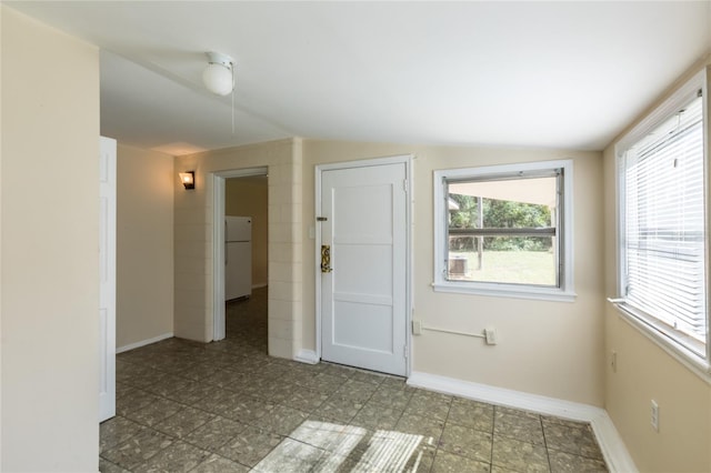 unfurnished room featuring vaulted ceiling and a healthy amount of sunlight