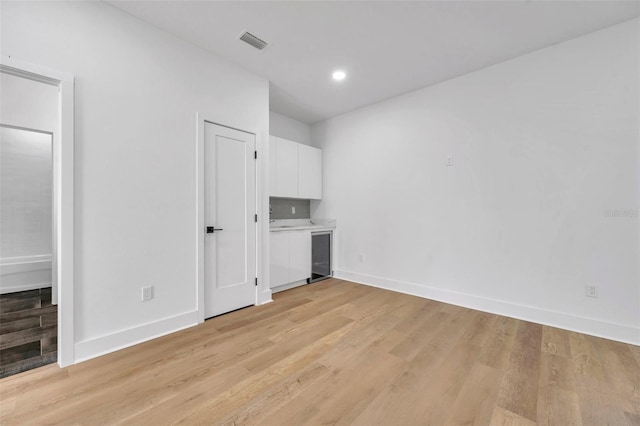 interior space with beverage cooler and light hardwood / wood-style flooring