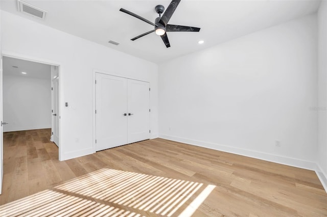 unfurnished bedroom with ceiling fan, hardwood / wood-style floors, and a closet