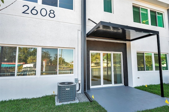 property entrance with central air condition unit and a patio