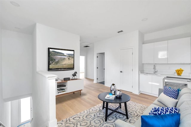 living room with sink and light hardwood / wood-style flooring