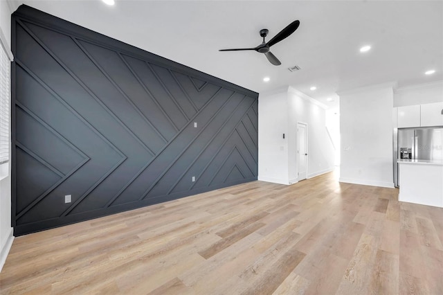 unfurnished living room with ceiling fan, ornamental molding, and light hardwood / wood-style flooring