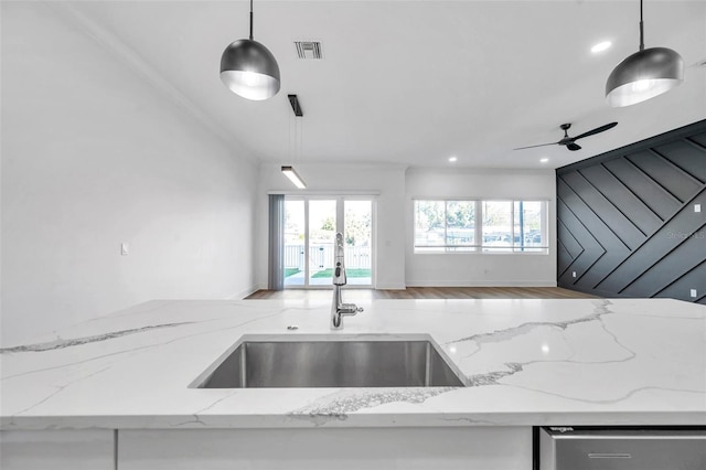 kitchen featuring decorative light fixtures, sink, light stone countertops, and ceiling fan