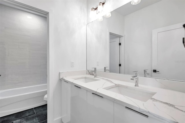 full bathroom with toilet, vanity, and tiled shower / bath