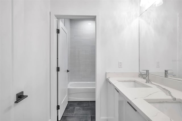 bathroom featuring tiled shower / bath combo, vanity, and tile patterned flooring