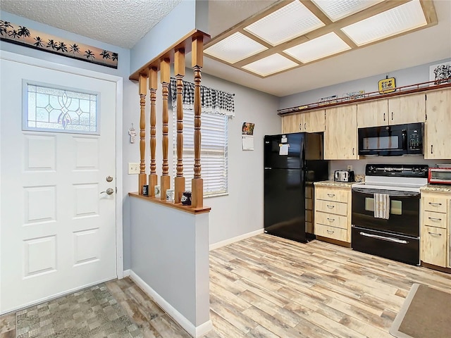 kitchen featuring light brown cabinetry, light hardwood / wood-style flooring, a wealth of natural light, and black appliances