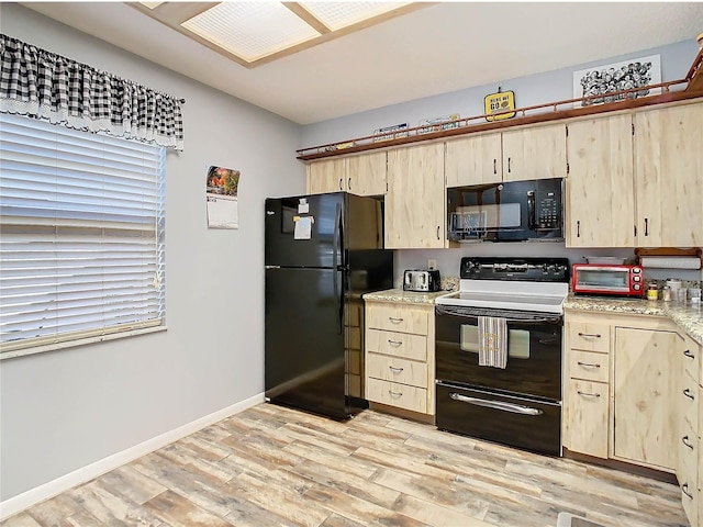 kitchen with light brown cabinetry, light hardwood / wood-style flooring, and black appliances