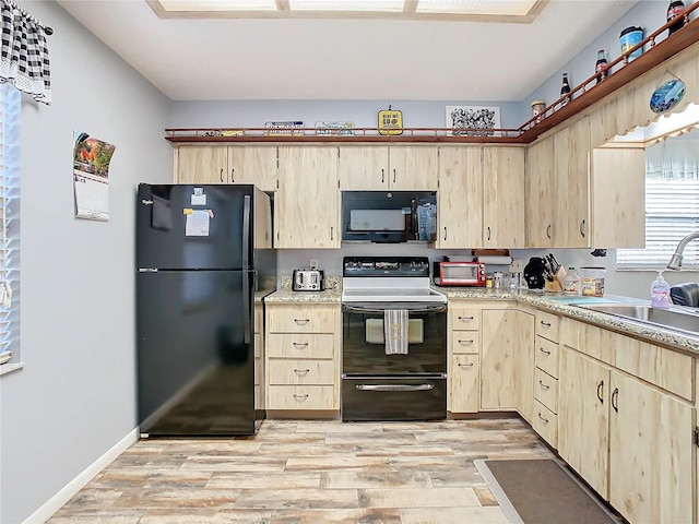 kitchen with light brown cabinetry, sink, light hardwood / wood-style floors, and black appliances