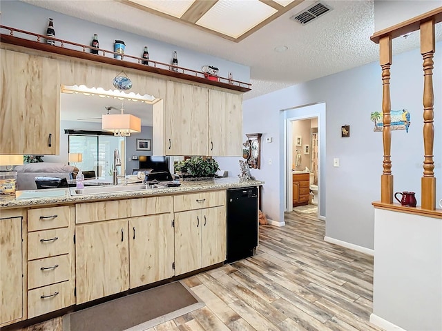 kitchen featuring dishwasher, sink, a textured ceiling, light brown cabinetry, and light wood-type flooring