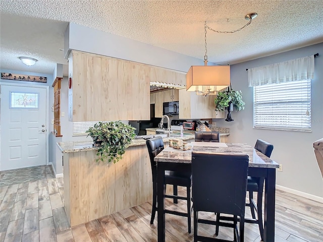 dining space featuring light hardwood / wood-style floors and a textured ceiling