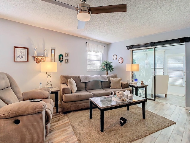 living room featuring a textured ceiling, light hardwood / wood-style flooring, and ceiling fan