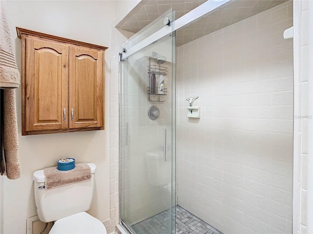 bathroom with toilet and a shower with shower door