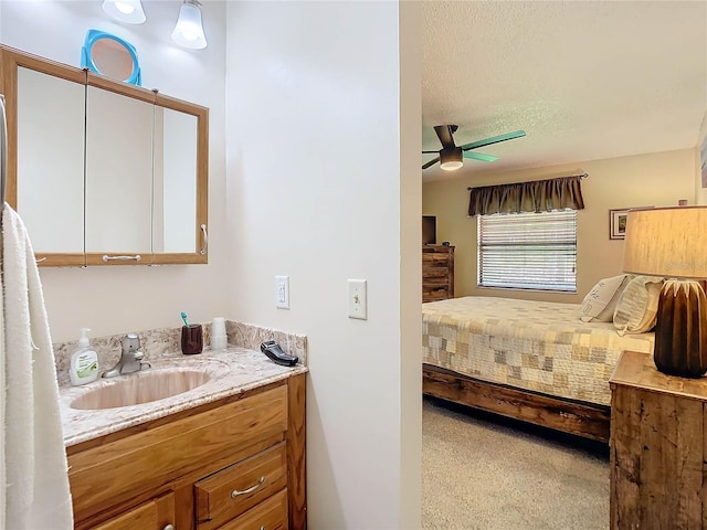 carpeted bedroom with a textured ceiling, ceiling fan, and sink