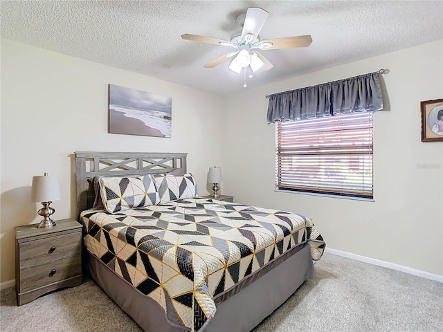 carpeted bedroom featuring ceiling fan and a textured ceiling