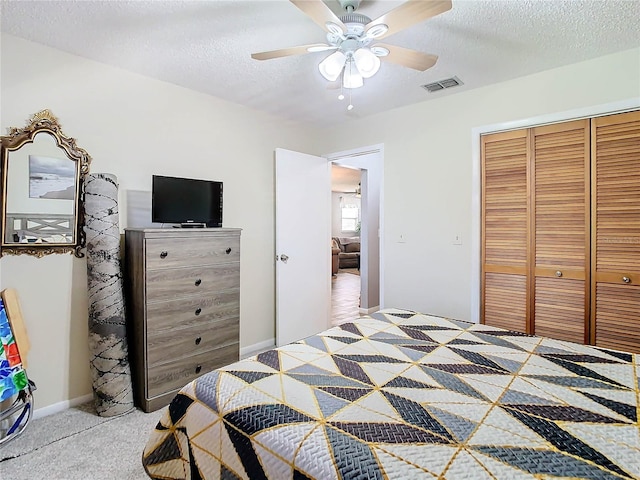 bedroom with ceiling fan, carpet floors, a textured ceiling, and a closet