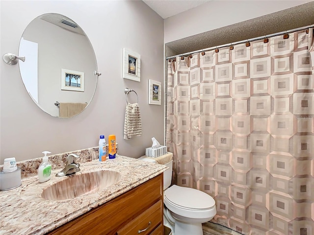 bathroom featuring vanity, curtained shower, and toilet