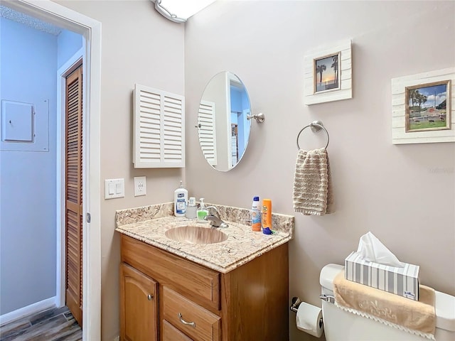 bathroom with hardwood / wood-style flooring, vanity, and toilet