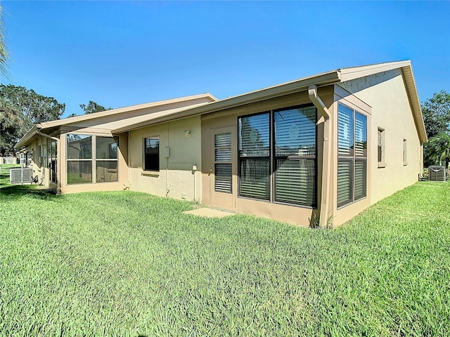 back of house featuring a lawn and central AC