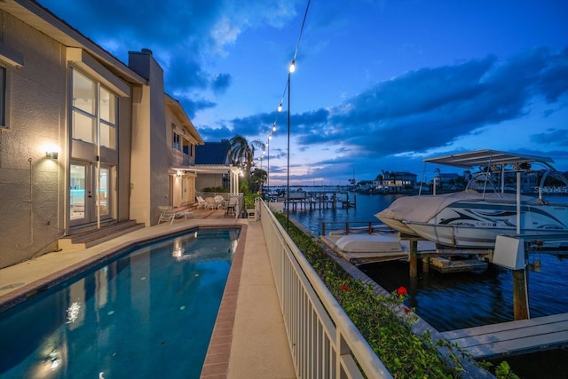 exterior space featuring french doors, a water view, and a boat dock