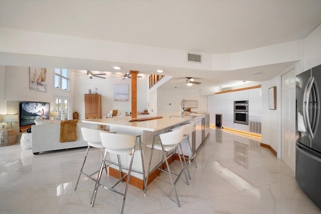 18 Winston Dr, Belleair, FL 33756 - kitchen featuring stainless steel appliances, modern cabinets, light marble finish floors, ceiling fan, and open floor plan