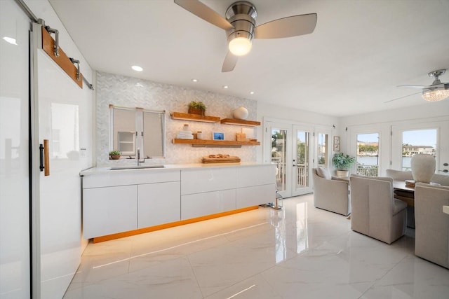 18 Winston Dr, Belleair, FL 33756 - kitchen featuring ceiling fan, light marble finish floors, french doors, a sink, and white cabinets