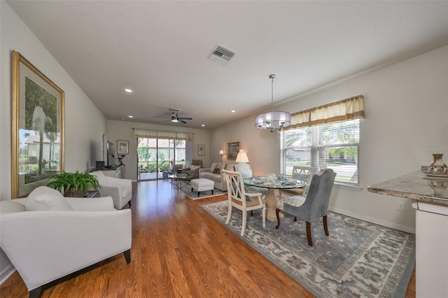 dining area featuring dark hardwood / wood-style floors and ceiling fan with notable chandelier