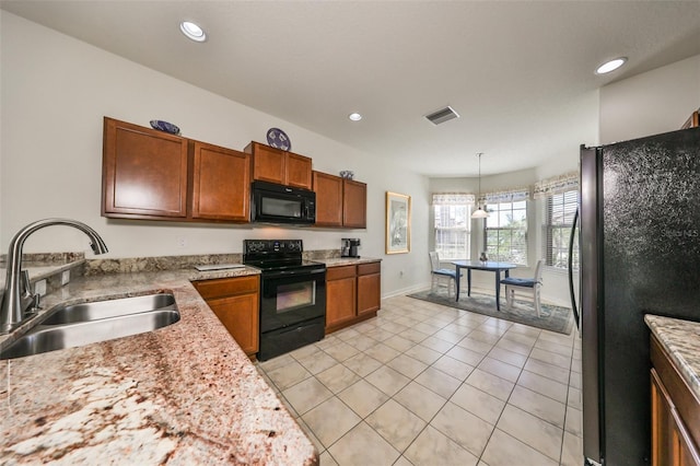 kitchen with light stone counters, sink, black appliances, hanging light fixtures, and light tile patterned flooring