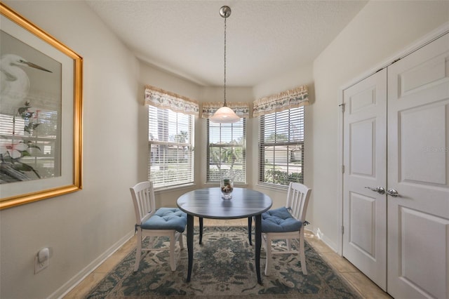 dining area with light tile patterned flooring and a textured ceiling