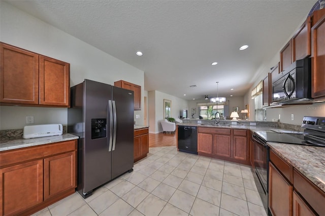 kitchen with pendant lighting, black appliances, sink, a notable chandelier, and kitchen peninsula