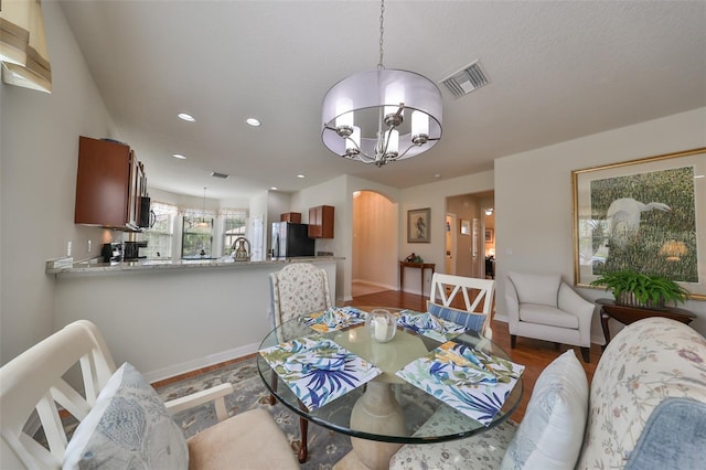 dining space with dark hardwood / wood-style flooring and an inviting chandelier