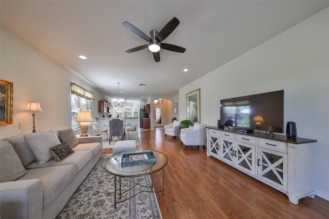 living room with hardwood / wood-style floors and ceiling fan with notable chandelier