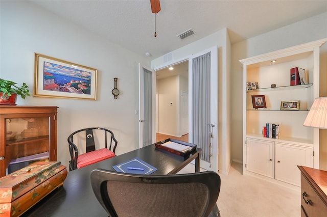 carpeted office space featuring a textured ceiling and ceiling fan