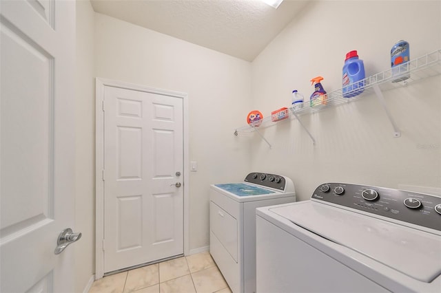 washroom featuring light tile patterned floors, a textured ceiling, and separate washer and dryer