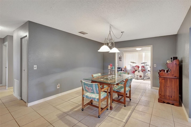 tiled dining area with a textured ceiling