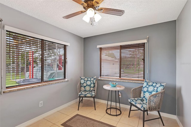 sitting room with a textured ceiling, a healthy amount of sunlight, and light tile patterned flooring