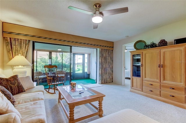 carpeted living room featuring a textured ceiling and ceiling fan