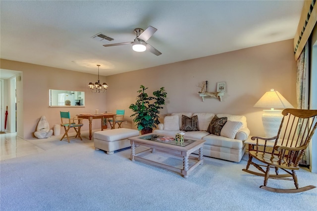 carpeted living room featuring ceiling fan with notable chandelier