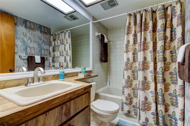 full bathroom with a skylight, vanity, shower / bath combo, and toilet