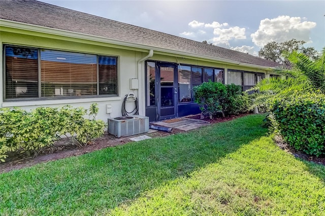 back of property featuring a yard and central AC unit