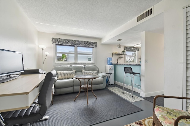 living room featuring a textured ceiling, concrete floors, and sink