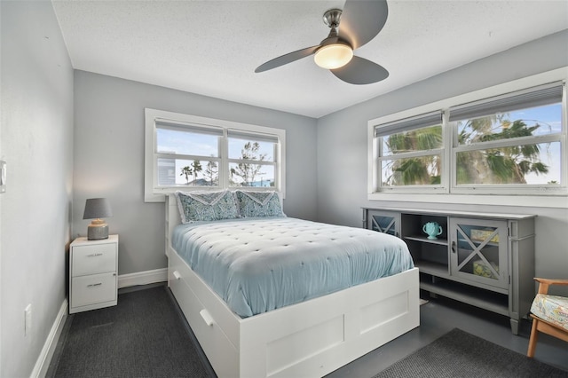 carpeted bedroom featuring ceiling fan and a textured ceiling