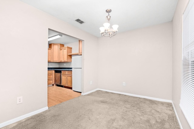 unfurnished dining area with visible vents, baseboards, light colored carpet, and a notable chandelier