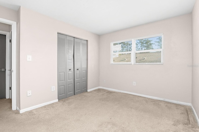 unfurnished bedroom featuring a closet, baseboards, and carpet floors