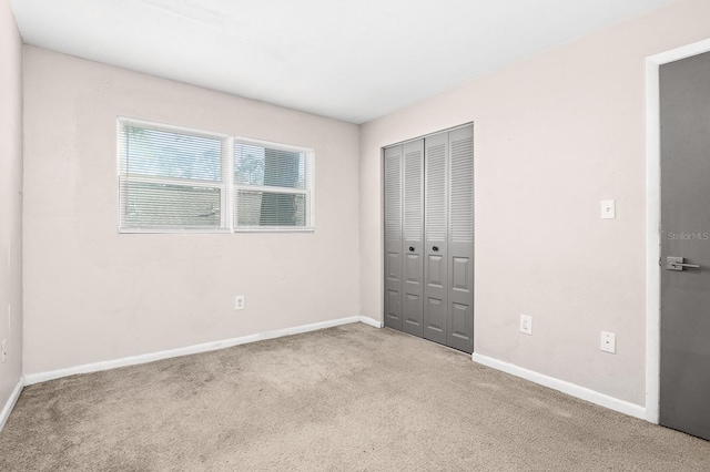 unfurnished bedroom with a closet, baseboards, and carpet