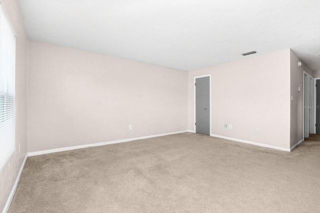 carpeted empty room with visible vents and baseboards