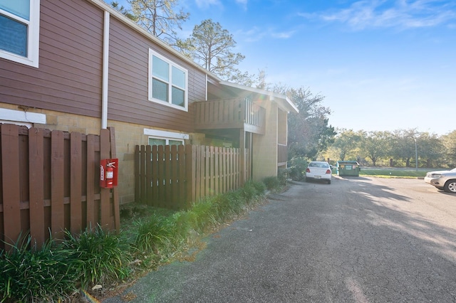 view of side of property featuring a balcony and fence